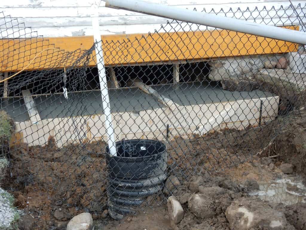 The form has been filled. A temporary sump pump keeps the site drained.
