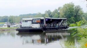 The GlassBarge passing the Mid Lakes marina heading east.