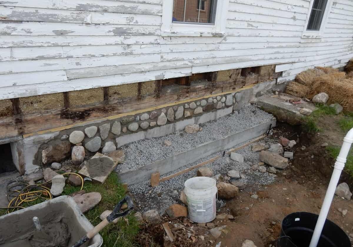 Field stones are placed on the face of the blocks to blend the new with the old.